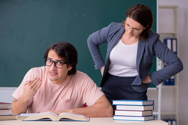 Régi női tanár és férfi diák az osztályteremben — Stock Fotó