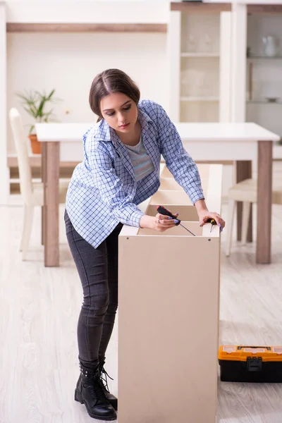 Young beautiful woman assembling furniture at home — Stock Photo, Image