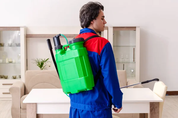 Jovem empreiteiro fazendo controle de pragas em casa — Fotografia de Stock