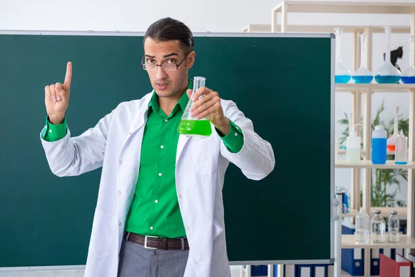 Joven profesor químico frente a pizarra —  Fotos de Stock