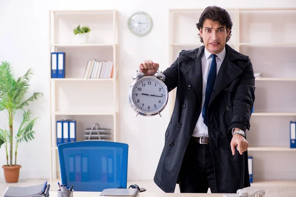 Ung manlig anställd på kontoret i time management koncept — Stockfoto