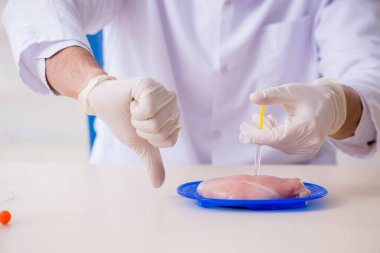 Erkek beslenme uzmanı gıda ürünlerini laboratuarda test ediyor.