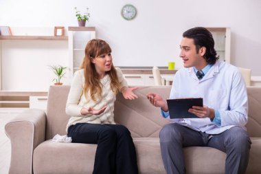 Genç bayan hasta erkek psikologla konuşuyor.