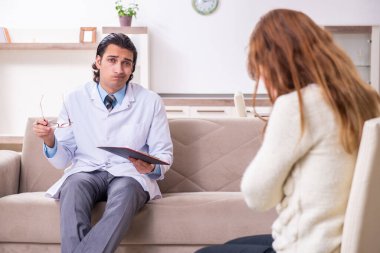 Genç bayan hasta erkek psikologla konuşuyor.