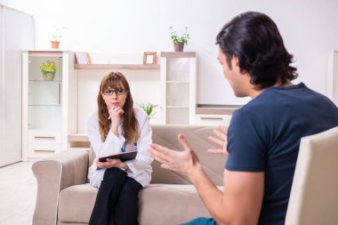 Genç bir erkek hasta kadın psikologla konuşuyor.