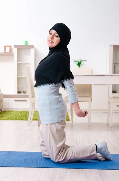 Jonge vrouw in hijab doet oefeningen thuis — Stockfoto