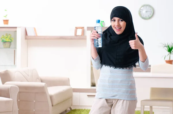 Mujer joven en hiyab haciendo ejercicios en casa — Foto de Stock