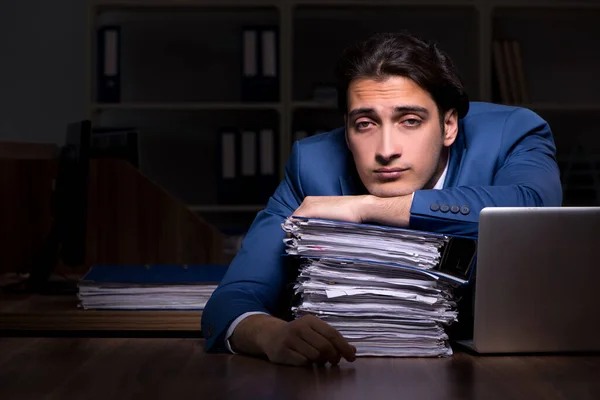 Joven empleado trabajando de noche en la oficina — Foto de Stock