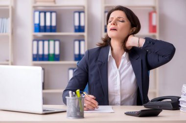 Ofiste acı çeken orta yaşlı kadın çalışan