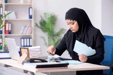 Ofiste çalışan tesettürlü kadın muhasebeci.