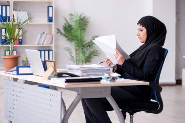 Ofiste çalışan tesettürlü kadın muhasebeci.
