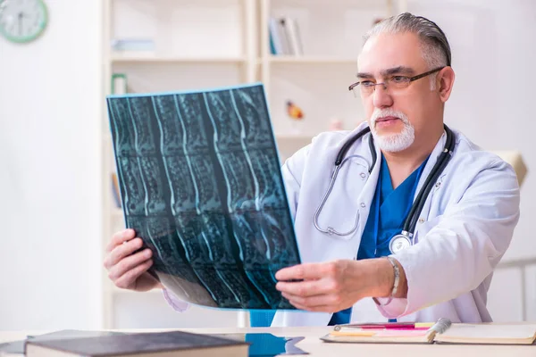 Gammal manlig läkare som arbetar på kliniken — Stockfoto