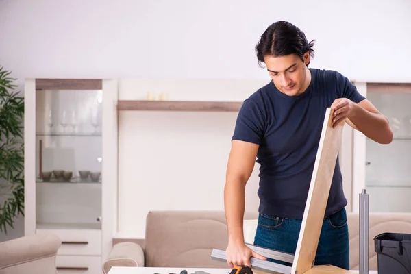 Young man repairing furniture at home