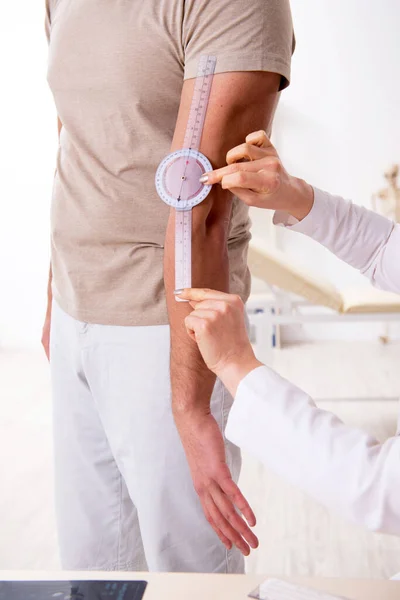 Médica verificando pacientes flexibilidade articular com goniômetro — Fotografia de Stock
