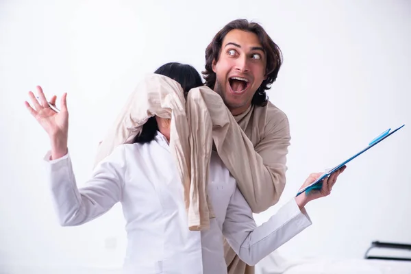 Old female psychiatrist visiting young male patient — Stock Photo, Image