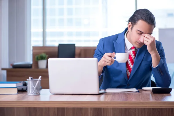 Jovem empresário bonito sentado no escritório — Fotografia de Stock