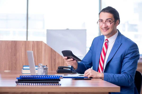 Jovem empresário bonito sentado no escritório — Fotografia de Stock