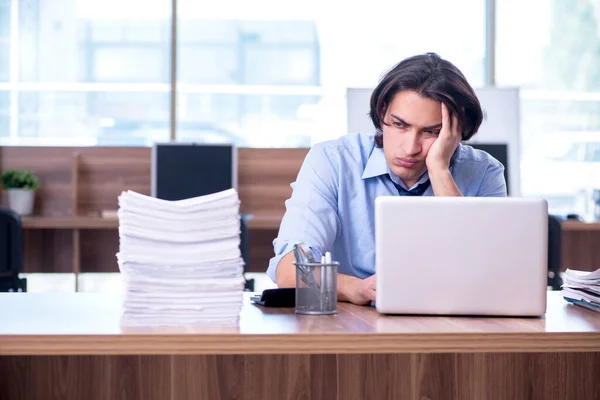 Jovem funcionário infeliz com excesso de trabalho — Fotografia de Stock