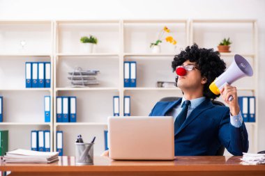 Genç palyaço işadamı ofiste çalışıyor.