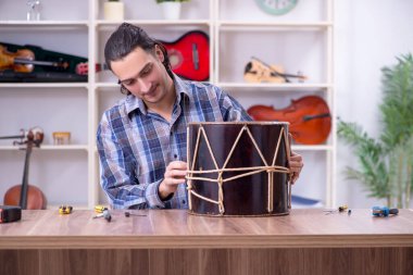 Davul tamir eden yakışıklı bir tamirci.