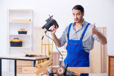 Genç erkek marangoz içeride çalışıyor.