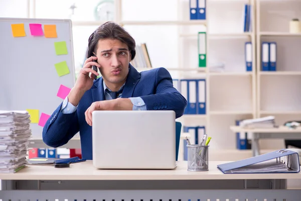 Young male employee unhappy with excessive work — Stock Photo, Image