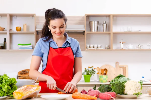Mujer joven con verduras en la cocina — Foto de Stock