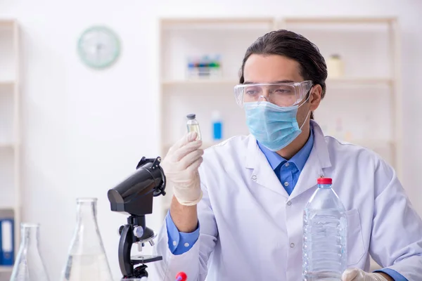 젊은 남성 화학자가 실험실에서 실험을 하는 모습 — 스톡 사진