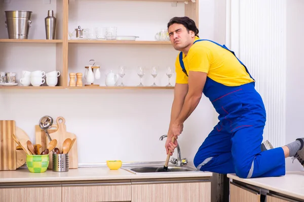 Jovem empreiteiro masculino reparando torneira em casa — Fotografia de Stock