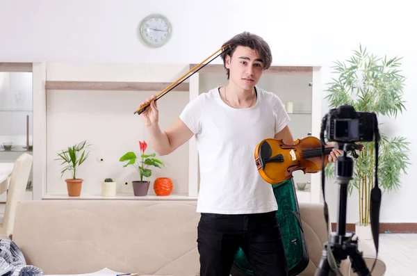 Mladý muž blogger hraje doma na housle — Stock fotografie