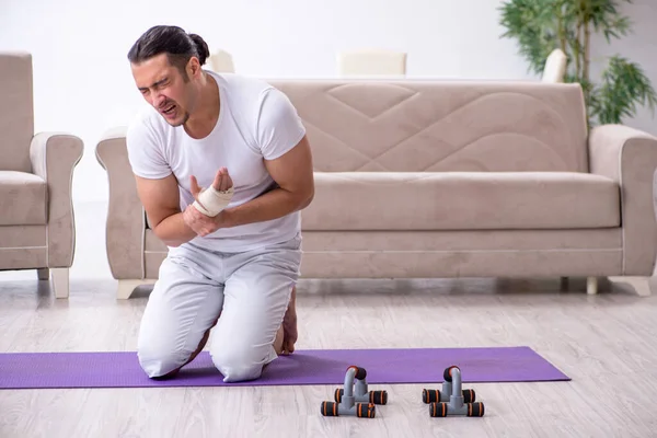 Mão ferido homem fazendo exercícios em casa — Fotografia de Stock