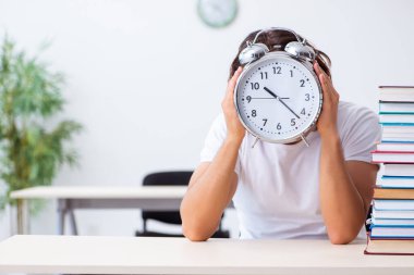 Sınıfta oturan genç erkek öğrenci.