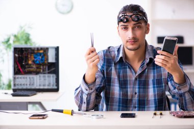 Genç yakışıklı teknisyen cep telefonu tamir