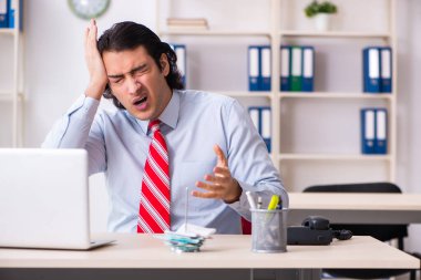 Ofiste acı çeken genç bir erkek işçi.