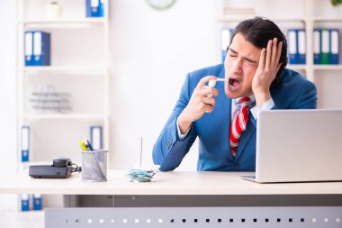 Ofiste acı çeken genç bir erkek işçi.