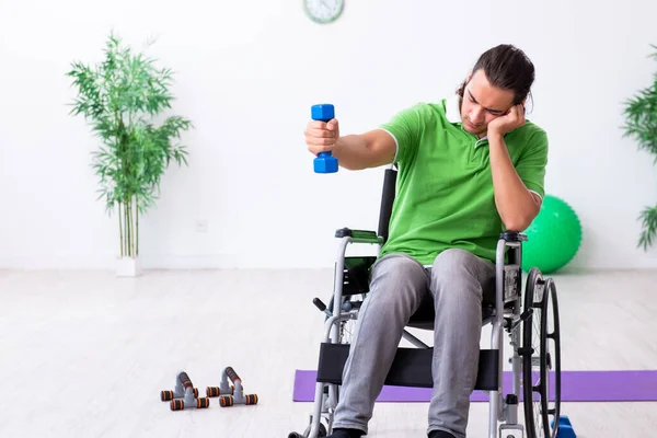 Joven en silla de ruedas haciendo ejercicios en interiores — Foto de Stock