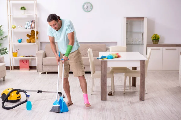 Joven herido limpiando la casa — Foto de Stock