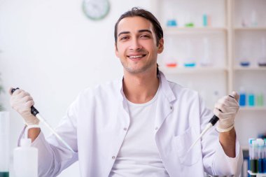 Laboratuvarda çalışan genç bir kimyager.