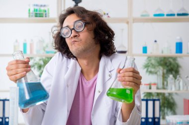 Laboratuvarda çalışan komik erkek kimyager.