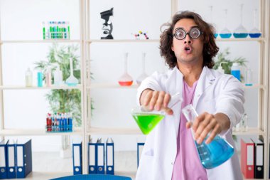 Laboratuvarda çalışan komik erkek kimyager.