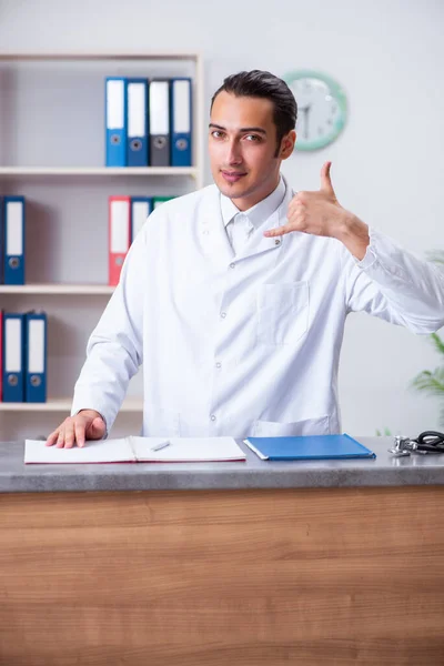 Ung manlig läkare i receptionen på sjukhuset — Stockfoto