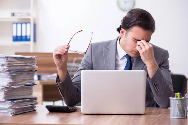 Joven empleado masculino infeliz con el trabajo excesivo —  Fotos de Stock