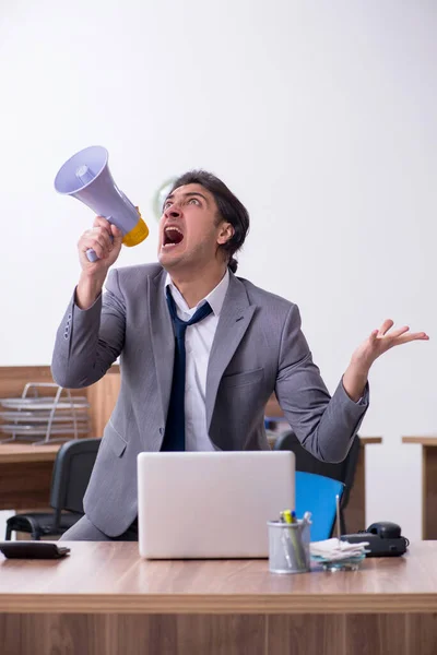 Giovane dipendente maschio infelice con il lavoro eccessivo — Foto Stock