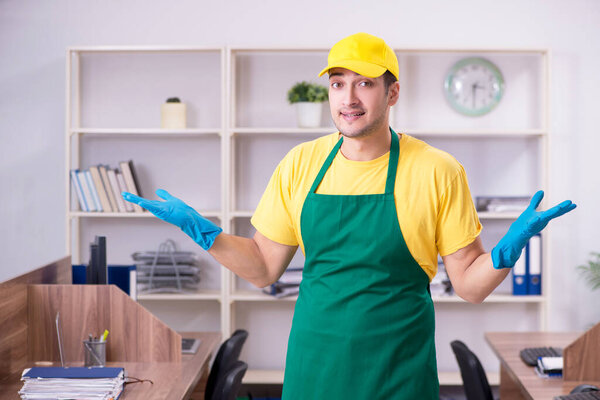 Молодой мужчина-подрядчик убирает офис