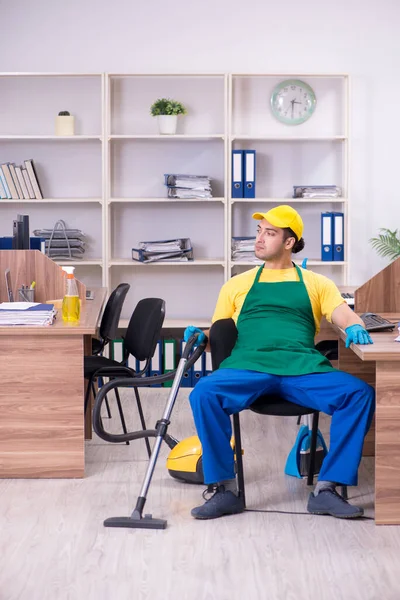 Joven contratista masculino limpiando la oficina — Foto de Stock