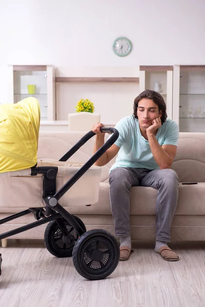 Jovem cuidando do bebê no carrinho — Fotografia de Stock