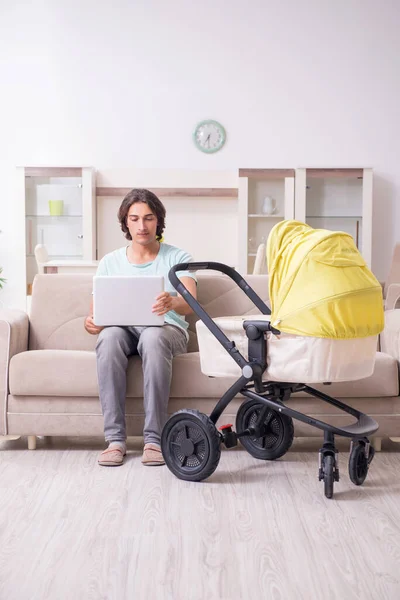 Young man looking after baby in pram — Stock Photo, Image