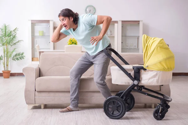 Joven cuidando al bebé en cochecito — Foto de Stock