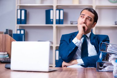 Genç yakışıklı işadamı ofiste çalışıyor.