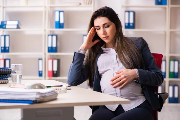 Mujer embarazada joven que trabaja en la oficina — Foto de Stock
